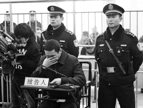 庭審中,29歲的李軍低著頭。
