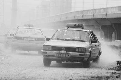 施工的道路上，車輛通過塵土飛揚。