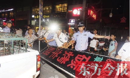 7月8日晚，鄭州市商城路一家占道經(jīng)營的攤販招牌被執(zhí)法隊員“登記保存”