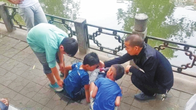 男孩被救出后，圍觀群眾幫他控水換衣服。