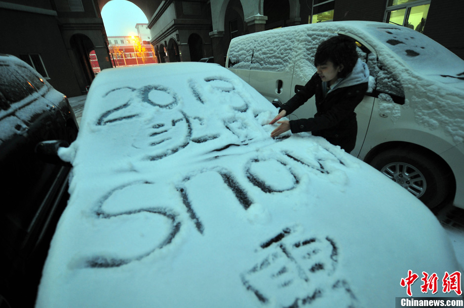 11月18日，行人在車輛的積雪上涂鴉。