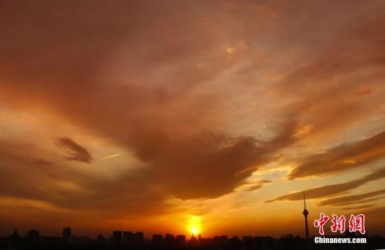 12月8日下午，強(qiáng)烈的西北風(fēng)光臨北京，吹散了籠罩全城上空的霧霾，冬日罕見的艷麗晚霞映紅了半邊天。