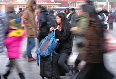 春運(yùn)首日，北京站客流量明顯增多，一名女孩在人流中等待進(jìn)站。