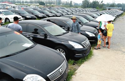 昨日，市民在山東棗莊一家拍賣公司場(chǎng)地上查看待拍賣公車。當(dāng)日，棗莊市103輛公車公開拍賣。新華社記者