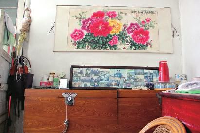 　陳會英將兒女的照片都裱起來，裝在一個大相框里，放在箱子上經(jīng)?？?，其中最多的就是劉金國的照片。