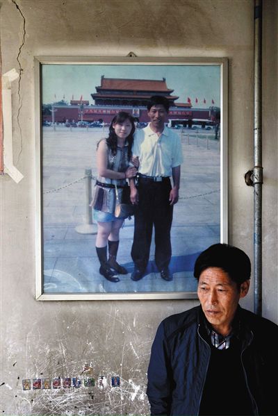11月14日，承德市平泉縣，潘小梅父母的家，潘小梅父親靠在墻上，身后掛著數(shù)年前他和潘小梅在北京的合影照片。新京報記者