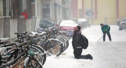 小伙子跪在樓前，一直抬頭看著樓上。 孫立國/攝