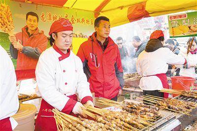 賣羊肉串攤位老板趙山（穿紅衣者）。新京報記者