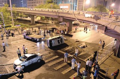 路虎沖下國(guó)貿(mào)橋砸中一輛起亞轎車(chē)，橋上厚達(dá)幾十厘米的水泥護(hù)欄被撞斷，碎石四處散落，數(shù)十群眾在現(xiàn)場(chǎng)圍觀。