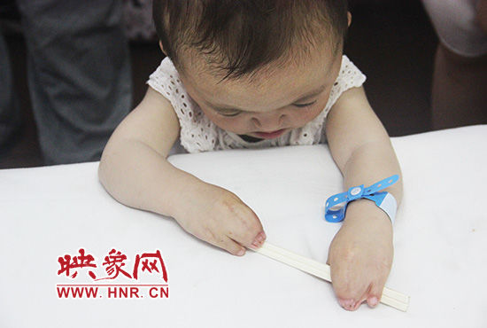 孩子握著筷子發(fā)呆。