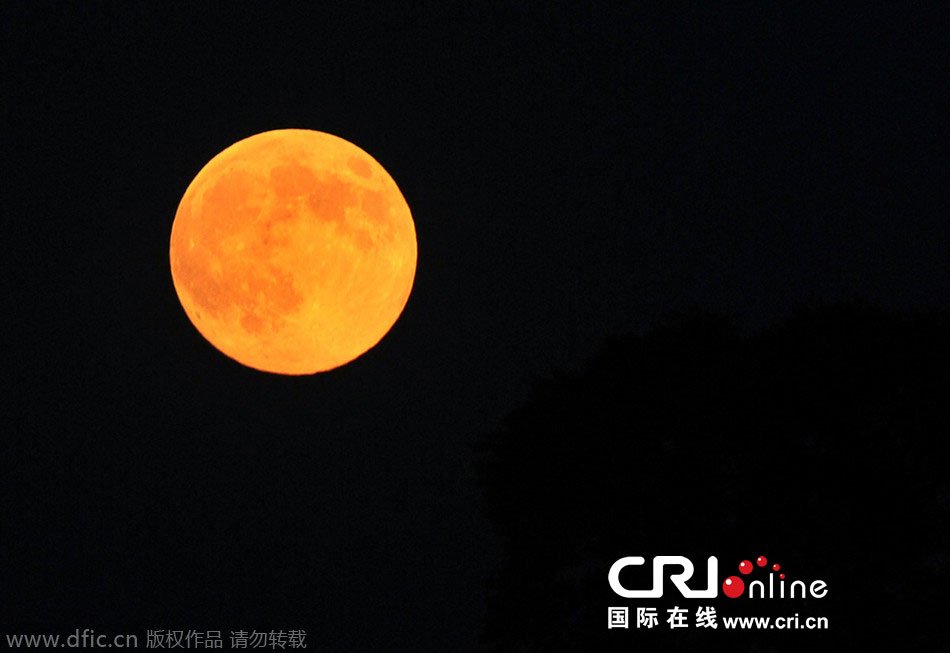 8月10日晚，一輪金燦燦的大月亮在遼寧省大連市東方升起。圖片來(lái)源：劉德斌/東方IC