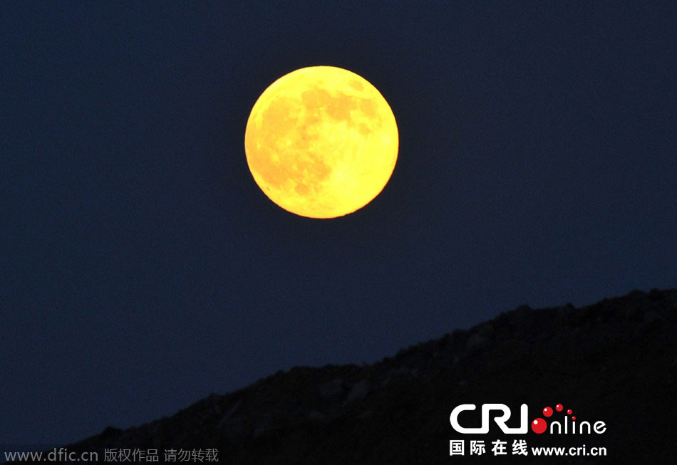 8月10日晚，一輪金燦燦的大月亮在遼寧省大連市東方升起。圖片來(lái)源：劉德斌/東方IC