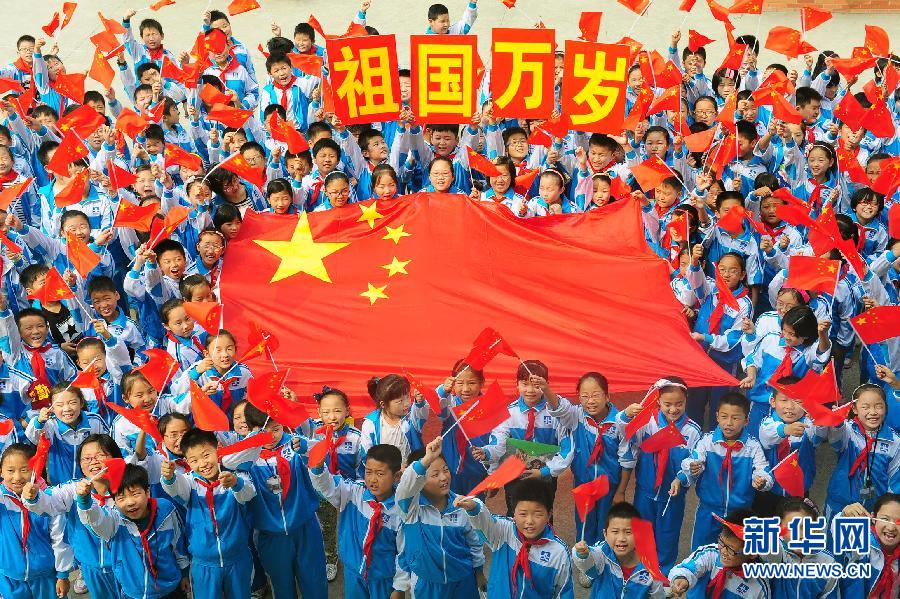 9月26日，安徽省阜陽市北城小學(xué)分校的學(xué)生與國旗合影。
