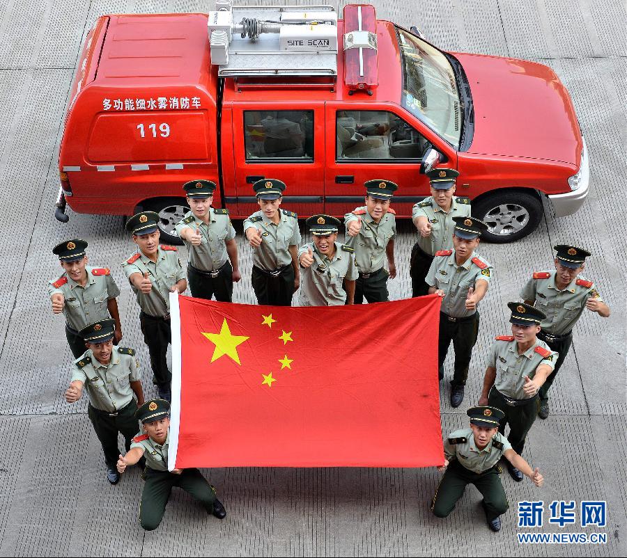  9月25日，武警浙江嘉興消防官兵與國旗合影。