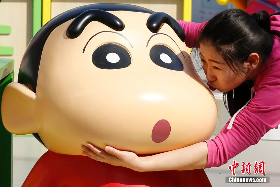 4月22日，游客與蠟筆小新合影?！跋灩P小新25周年紀(jì)念特展”日前在北京開展，吸引了不少市民游客。