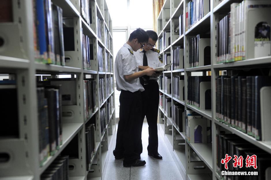 5月8日，武漢輕工大學(xué)保安吳濤與江力在圖書館交流學(xué)習(xí)。中新社發(fā) 張暢 攝