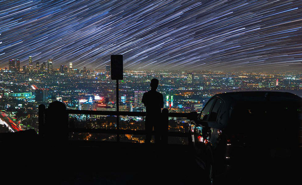 照片中，一名男子看著流星和隕星劃過天空。（網(wǎng)頁截圖）