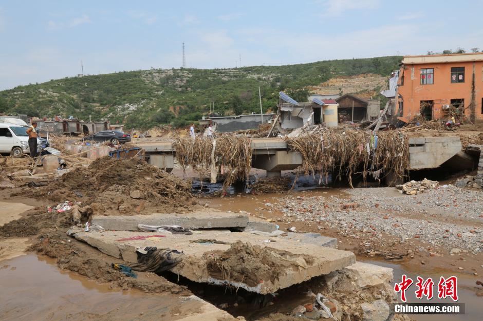 圖為洪水過后，坍塌的橋梁上遺落大量雜草。