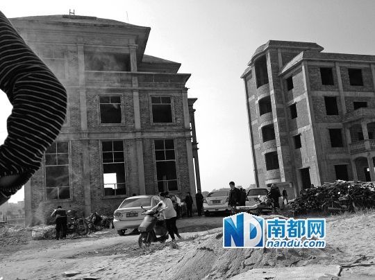 兩棟被舉報的違建樓下昨日一度聚集了超過百人，城管離開后逐漸散去。南都記者張志韜實習生宋超攝