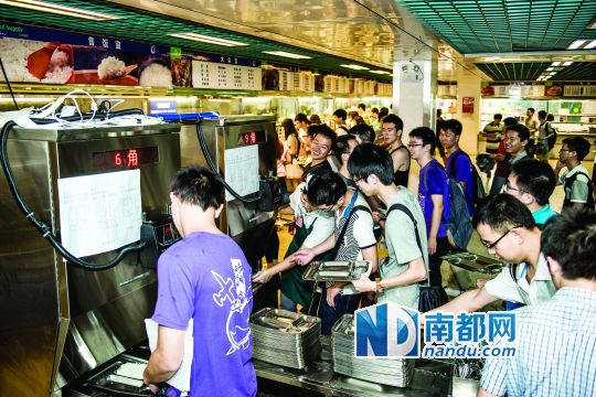 昨日，華南理工大學(xué)一食堂內(nèi)，學(xué)生們正在使用新安裝的自動打飯機(jī)打飯。中新社發(fā)