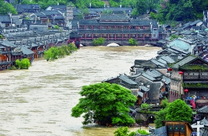 7月16日,沱江兩邊的商鋪和遠(yuǎn)處的虹橋仍淹沒在洪水中。 新華社發(fā)
