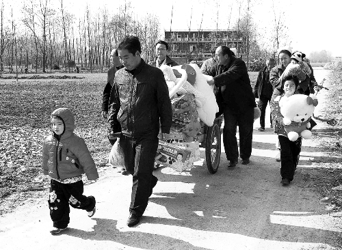 姐（左一）弟（右一護士懷中男嬰）返鄉(xiāng)，愛心捐贈滿滿一架子車。
